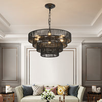 Black hemp rope tiered chandelier hanging in an elegant living room with paneled walls, boho ceiling light fixture