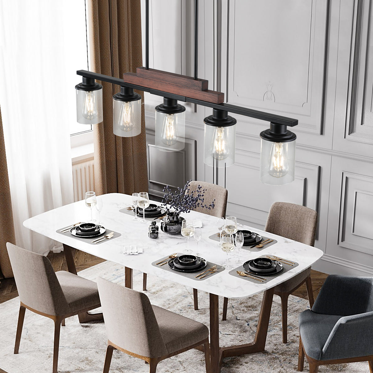 The Winslow Farmhouse Kitchen Island Chandelier over a dining table with five clear glass shades and a wood and black metal frame