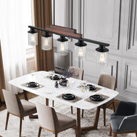 The Winslow Farmhouse Kitchen Island Chandelier over a dining table with five clear glass shades and a wood and black metal frame