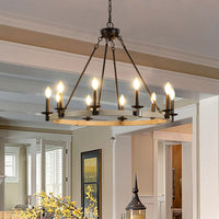 A close-up view of The Ashcombe Round Candle Chandelier installed in a home hallway, showcasing its sophisticated metal structure and warm ambient lighting.