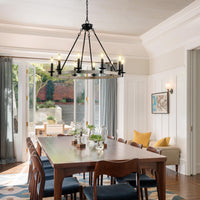 The Ashcombe Round Candle Chandelier positioned above a wooden dining table, creating a warm and inviting atmosphere for a dining space.
